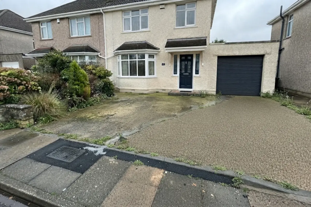Weathered resin driveway covered in moss before pressure washing